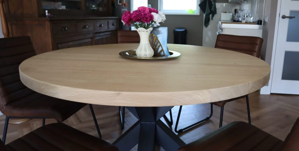 Massief eikenhouten, ronde tafel op een zwart stalen onderstel.